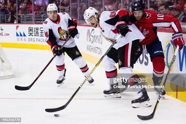 Erik Karlsson of the Ottawa Senators and Brett Connolly of the Washington Capitals battle for the puck in the first period at Capital One Arena on...