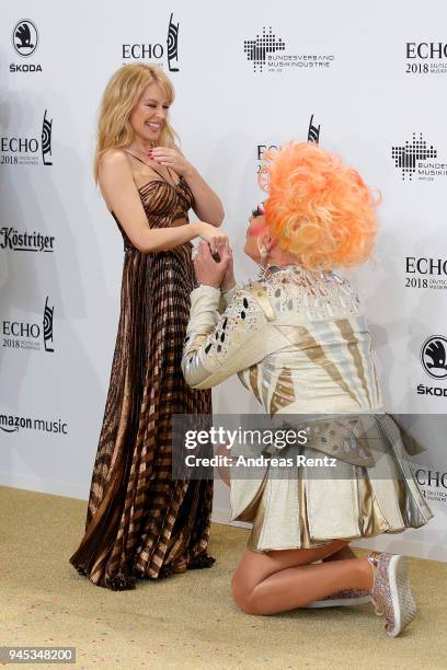 German drag queen Olivia Jones kneels down in front of Kylie Minogue as they arrive for the Echo Award at Messe Berlin on April 12, 2018 in Berlin,...