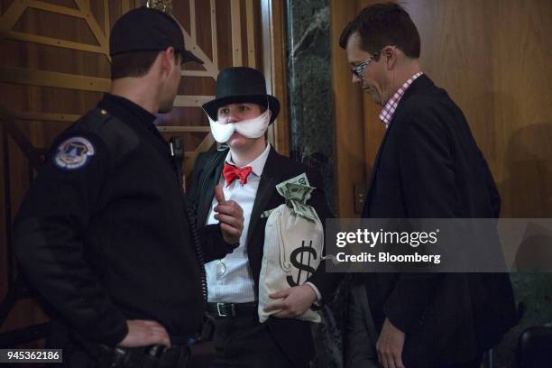 An attendee dressed as the "Monopoly Man" exits a Senate Banking, Housing & Urban Affairs Committee hearing with Mick Mulvaney, acting director of...