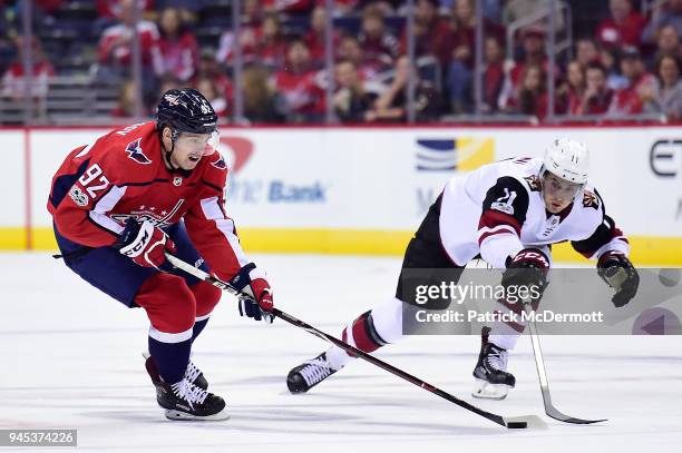 Evgeny Kuznetsov of the Washington Capitals battles for the puck against Brendan Perlini of the Arizona Coyotes in the first period at Capital One...