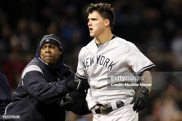 Tyler Austin of the New York Yankees is restrained by Yankees hitting coach Marcus Thames after fighting Joe Kelly of the Boston Red Sox during the...