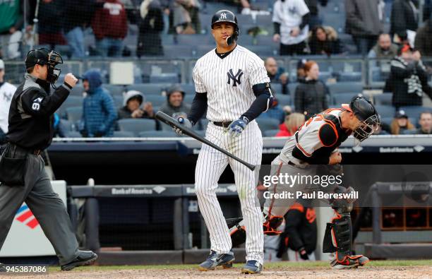 Giancarlo Stanton of the New York Yankees reacts to striking out to end the game as catcher Caleb Joseph of the Baltimore Orioles pumps his fist and...