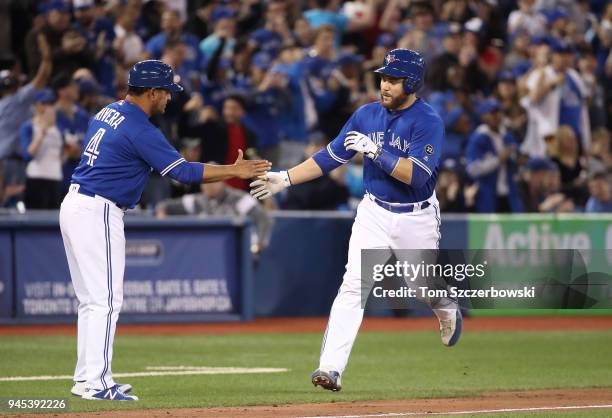 Russell Martin of the Toronto Blue Jays is congratulated by third base coach Luis Rivera after hitting a two-run home in the seventh inning during...