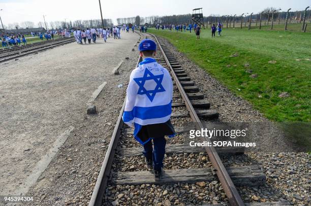 Man carries a Israeli flag at the former Nazi German Auschwitz-Birkenau death camp during the 'March of the Living' at Oswiecim. The annual march...