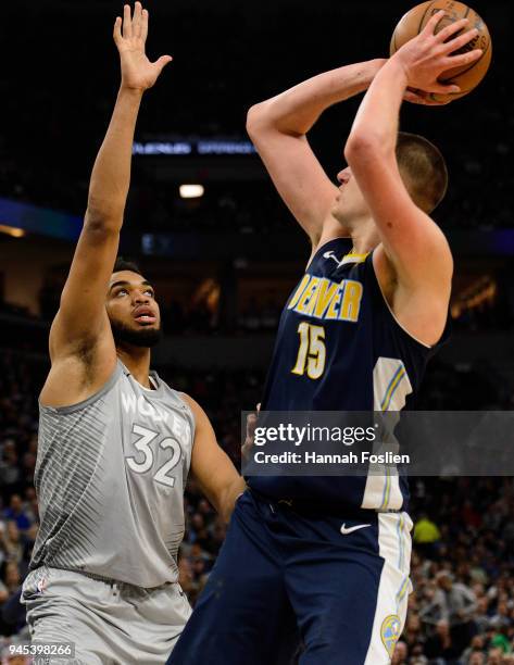 Karl-Anthony Towns of the Minnesota Timberwolves defends against Nikola Jokic of the Denver Nuggets during the third quarter of the game on April 11,...