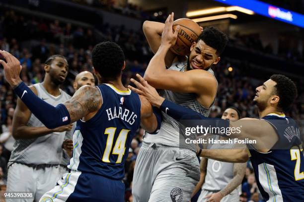 Karl-Anthony Towns of the Minnesota Timberwolves rebounds the ball against Gary Harris and Jamal Murray of the Denver Nuggets during the fourth...