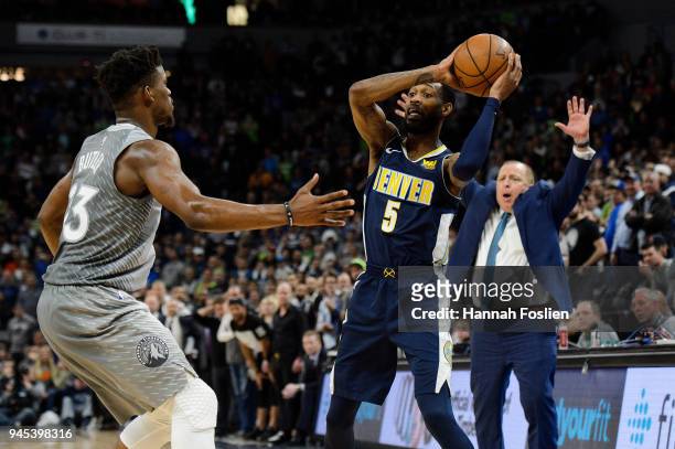 Jimmy Butler of the Minnesota Timberwolves defends against Will Barton of the Denver Nuggets as head coach Tom Thibodeau of the Minnesota...