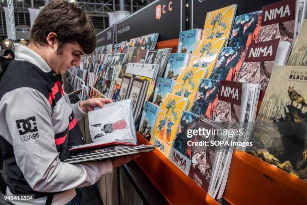 Young visitor seen selecting comics books to buy. Opening of the 36th Barcelona International Comic Fair from 12th-15th April 2018 in Fira Barcelona...