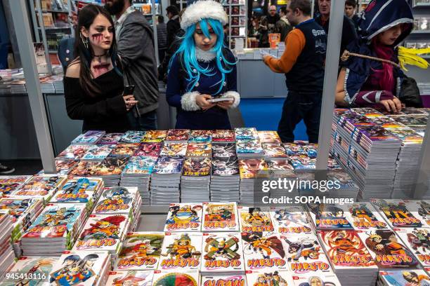 Young girls seen wearing cosplay costumes while selecting Naruto's mangas. Opening of the 36th Barcelona International Comic Fair from 12th-15th...