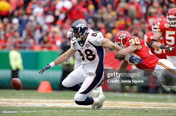 Tony Scheffler of the Denver Broncos reaches for the ball while being tackled by Mike Brown of the Kansas City Chiefs during their NFL game on...