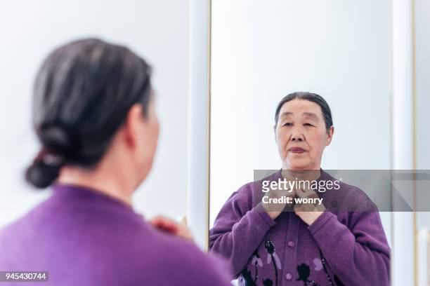 senior woman dressed in front of mirror - senior getting dressed stock pictures, royalty-free photos & images