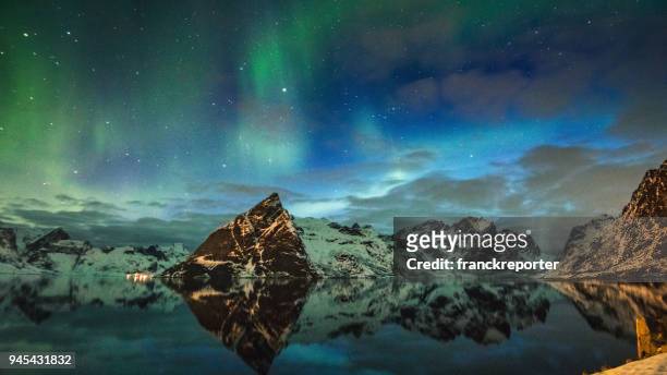 view of reine at lofoten with the aurora borealis - finnish lapland stock pictures, royalty-free photos & images