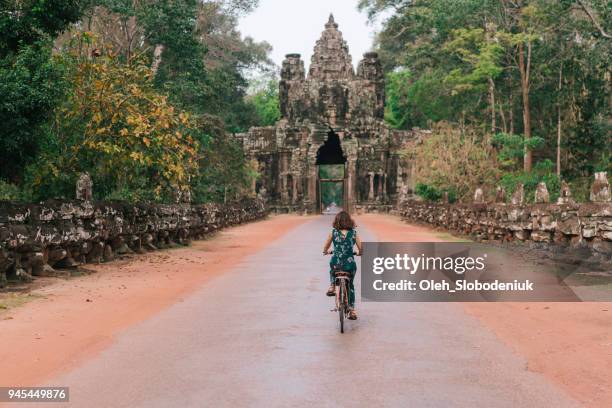 jovem bicicleta de equitação mulher caucasiana em angkor wat - traditionally cambodian - fotografias e filmes do acervo