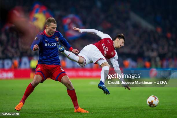 Aleksei Berezutski of CSKA Moskva tackles Mesut Ozil of Arsenal during the UEFA Europa League quarter final leg two match between CSKA Moskva and...