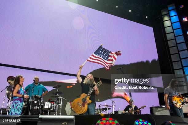 Jamey Johnson waves an American flag at Farm Aid at the KeyBank Pavilion in Burgettstown, Pennsylvania, United States on September 16, 2017.