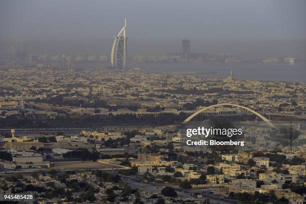 The Burj al Arab hotel, top center, operated by Jumeirah International LLC, stands beyond residential housing and the Arch pedestrian bridge, right,...