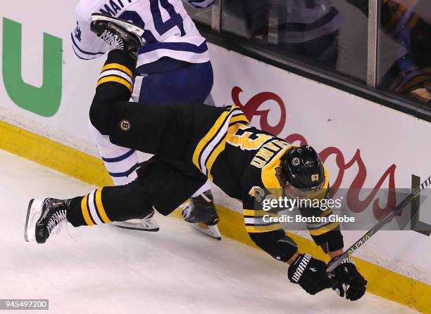 Boston Bruins player Brad Marchand goes flying into the boards while chasing a loose puck behind the Toronto net in the first period of Game One of...