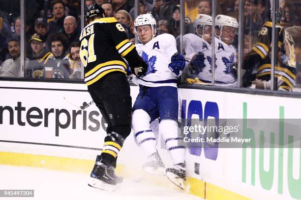 Rick Nash of the Boston Bruins checks Morgan Rielly of the Toronto Maple Leafs into the boards during the first period of Game One of the Eastern...