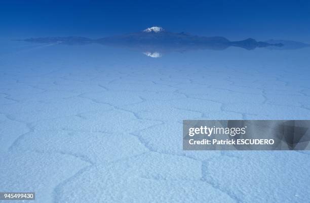 M?tres d'altitude, le "Salar de Uyuni" est le plus grand d?sert de sel du monde. En arri?re plan, le volcan Tunupa, surmont? d'une fine calotte de...