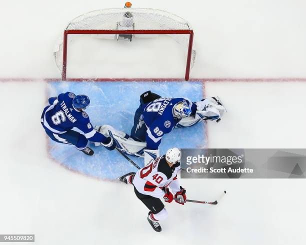 Goalie Andrei Vasilevskiy of the Tampa Bay Lightning stretches to make a save against Michael Grabner of the New Jersey Devils in Game One of the...
