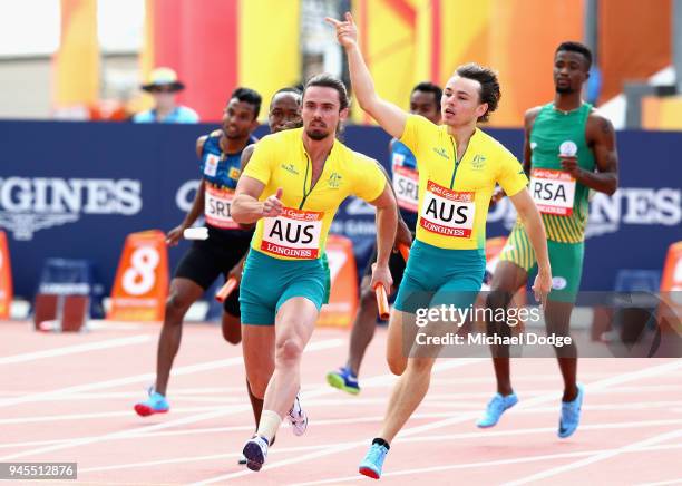 Josh Clarke of Australia takes the baton from Jack Hale of Australia on the last leg of the Men's 4x100 metres relay heats during Athletics Track &...