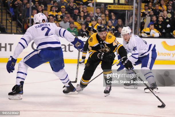 David Krejci of the Boston Bruins reaches for the puck against Ron Hainsey and Morgan Rielly of the Toronto Maple Leafs during the First Round of the...