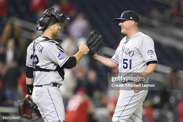 Chris Iannetta of the Colorado Rockies and Jake McGee celebrate a win after a baseball game against the Washington Nationals at Nationals Park on...