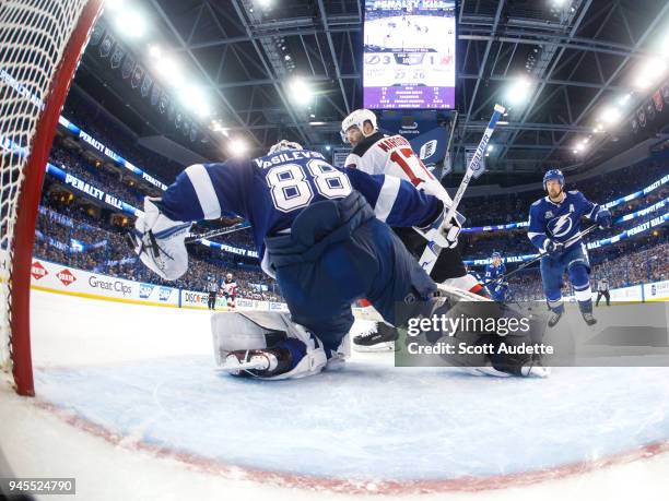 Goalie Andrei Vasilevskiy of the Tampa Bay Lightning knocks the puck away from Patrick Maroon of the New Jersey Devils in Game One of the Eastern...