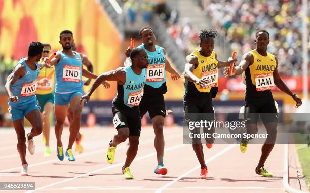 Javon Francis of Jamaica and Ramon Miller of the Bahamas take the baton on the last leg compete in the Men's 4x400 metres relay heats during athletic...