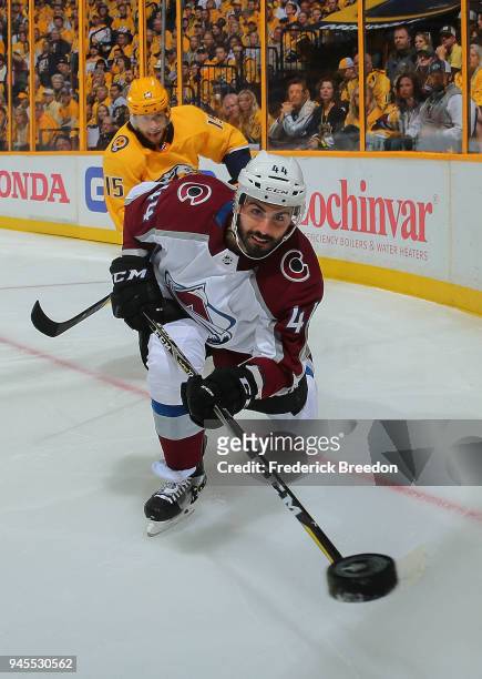 Mark Barberio of the Colorado Avalanche dumps the puck as Craig Smith of the Nashville Predators pursues during the first period in Game One of the...