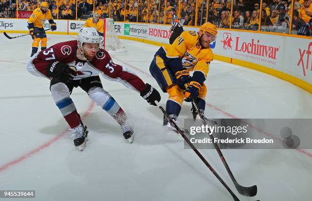 Compher of the Colorado Avalanche and Mattias Ekholm of the Nashville Predators poke at a loose puck during the second period in Game One of the...