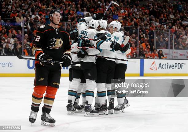 Josh Manson of the Anaheim Ducks skates by, as the San Jose Sharks celebrate a goal by Evander Kane in Game One of the Western Conference First Round...