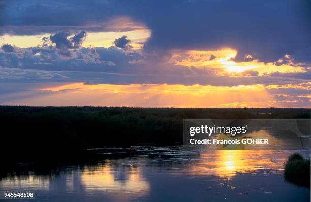 SOLEIL COUCHANT DANS LA TAIGA SUR LA RIVIERE CHURCHILL, MANITOBA, CANADA.