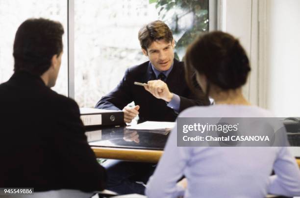 Jeune couple signant un contrat dans une banque pour un pr?t immobilier.