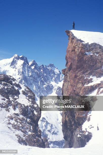 On the Rif peak, a mountaineer admires the Pelvoux Mount from the Mon?tier glacier. Sur le Pic du rif, un alpiniste admire le mont Pelvoux 3943m...