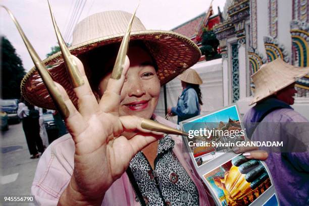 THAILAND.BANGKOK.WOMAN SELLING POST CARDS AND FALSE NAILS USED FOR DANCING AT THE WAT PO TEMPLE ENTRANCE THAILANDE.BANGKOK.A L'ENTREE DU TEMPLE WAT...