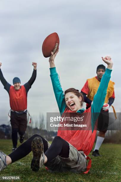 caucasian woman celebrating with arms raised, scoring points in the end zone, in a game of flag football. - touchdown stock pictures, royalty-free photos & images