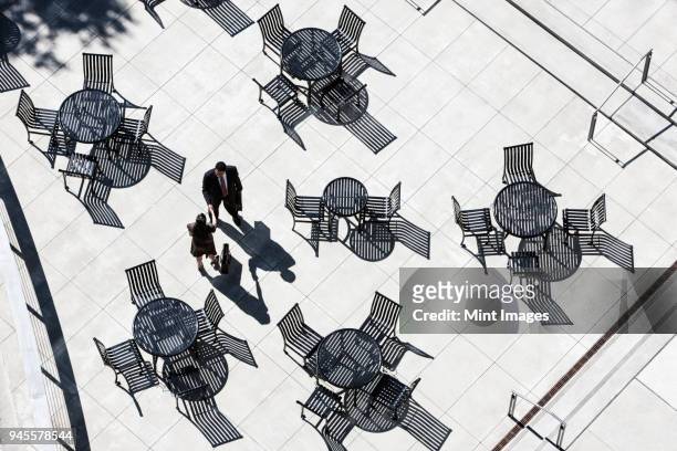 view from above of two business people meeting outside in an open air cafe area. - secret handshake stock pictures, royalty-free photos & images