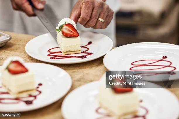 chef hands placing a layered desert on a plate, presentation of a sweet dish. - dessert foto e immagini stock