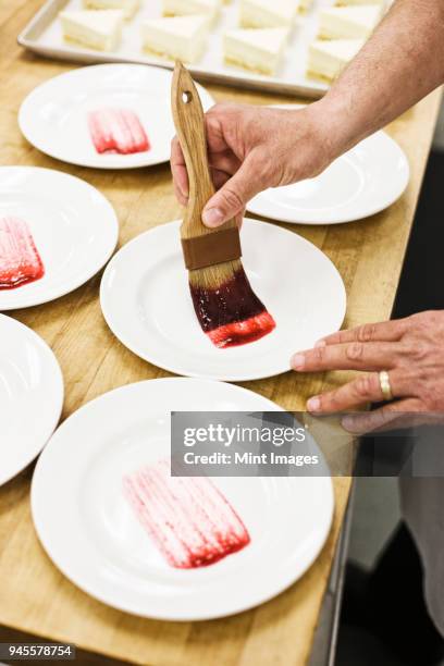 chef hands preparing a desert plate. - strawberry syrup stock pictures, royalty-free photos & images