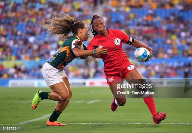 Charity Williams of Canada holds off Mathrin Simmers of South Africa to score a try during the Rugby Sevens Women's Pool A match between Canada and...