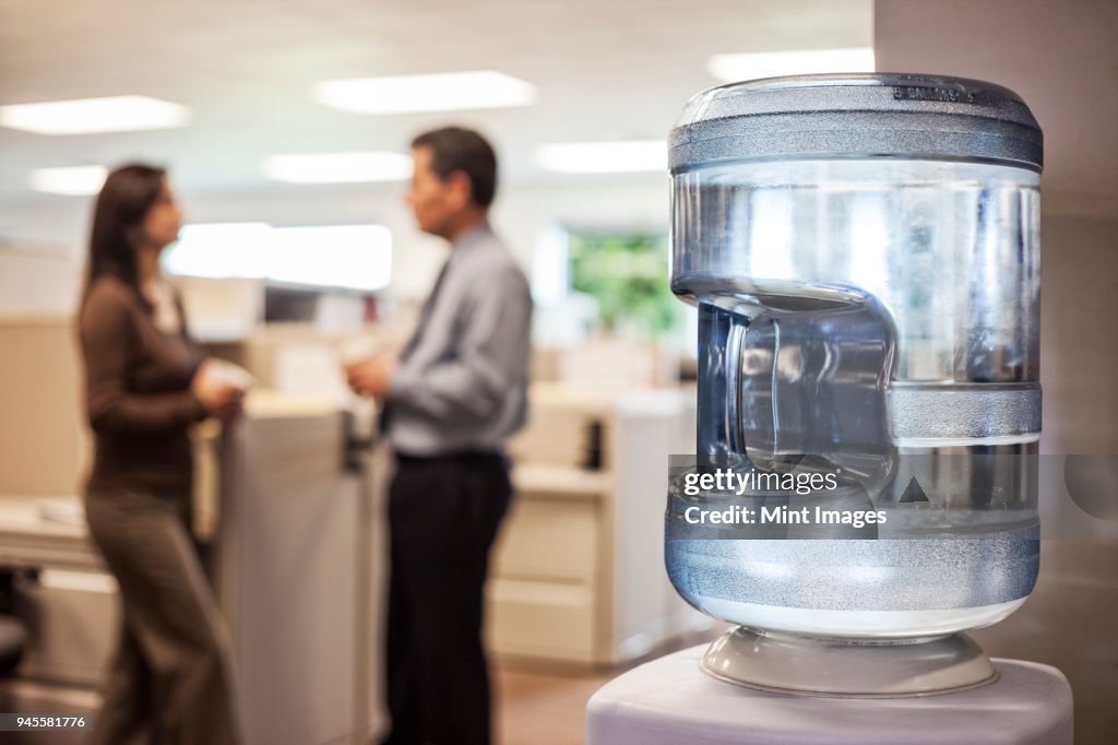 Caucasian man and woman executives in cubicle area of new office space