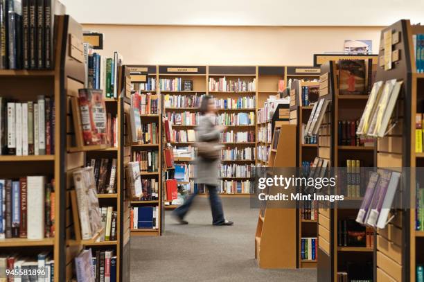 caucasian female browsing through books in a bookstore. - librairie photos et images de collection