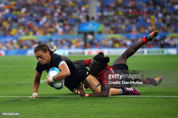 Niall Williams of New Zealand scores a try past Michelle Omondi of Kenya during the Rugby Sevens Women's Pool A match between New Zealand and Kenya...