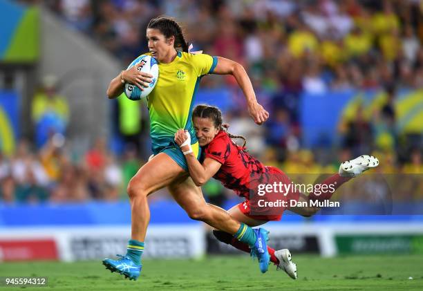 Charlotte Caslick of Australia is tackled by Jasmine Joyce of Wales during the Rugby Sevens Women's Pool B match between Australia and Wales on day...