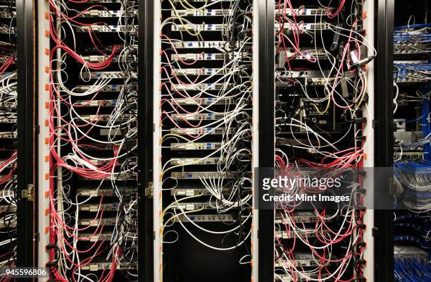 closeup of cat 5 cable bundle system in a computer server room - cable mess stockfoto's en -beelden