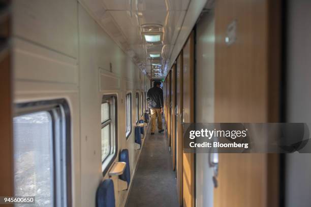 An armed police officer patrols a coach corridor of a Green Line Express train, an express service operated by Pakistan Railways between Islamabad...