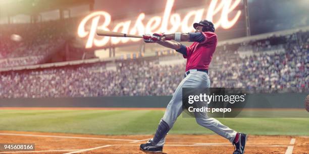 professionele honkbal slagman opvallend honkbal tijdens nacht spel in stadion - at bat stockfoto's en -beelden