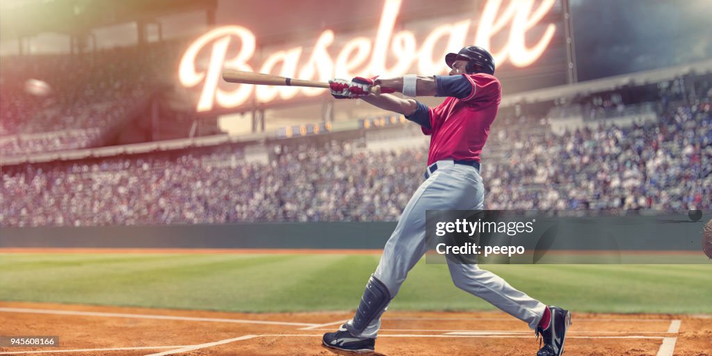 Professional Baseball Batter Striking Baseball During Night Game In Stadium