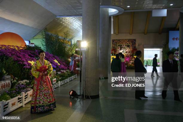 An attendant stands at a display at at the 20th 'Kimilsungia' festival flower show in Pyongyang on April 13, 2018. When nuclear-armed North Korea put...